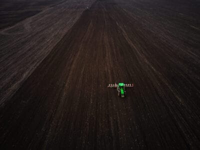 Precíziós vetés drónfelvételen – modern traktor szántóföldön vetőgéppel.